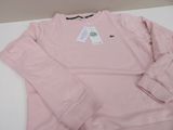pink long sleeved t - shirt on a white surface with a tag on it