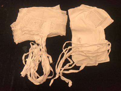 two pieces of white clothing on a black surface