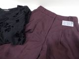 purple pants with black flowers on them and a black shirt on a white background
