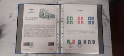 an open book with stamps on it sitting on a table
