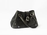 the black leather handbag is sitting on a white surface