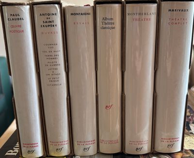 four books are stacked on top of each other on a table