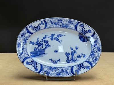 blue and white platter with birds and flowers on it