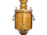 une urne ancienne en laiton posée sur un socle et munie d'une poignée en bois