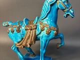 statue of a blue horse on a blue base with gold accents