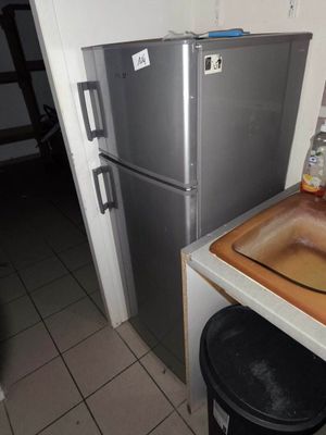 une petite cuisine équipée d'un évier et d'un réfrigérateur