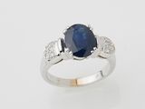 un gros plan d'une bague en saphir et diamants sur fond blanc