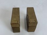 pair of gold colored metal boxes on a white surface