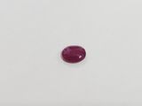 a red ruby stone on a white surface