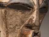 gros plan sur une sculpture en bois représentant le visage d'un homme