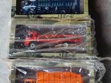 trois camions miniatures qui se trouvent dans une boîte