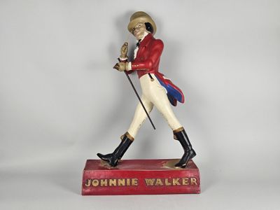 figurine représentant un homme vêtu d'une veste rouge et d'un pantalon blanc, tenant une canne