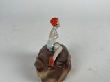 a figurine of a man riding a skateboard on a rock