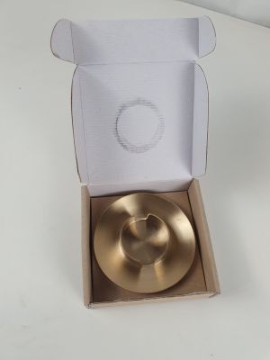 a gold plate in a cardboard box on a table