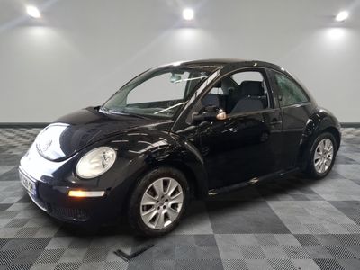 une photo d'une Coccinelle Volkswagen noire garée dans un garage
