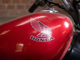 a red motorcycle parked in front of a brick wall