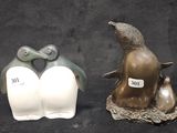 two figurines of penguins on a black background