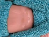 a doll that is wearing a blue sweater and mittens