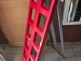 a picture of a red ladder leaning up against a wall