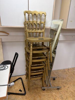 une pile de chaises et un miroir dans un coin de la pièce
