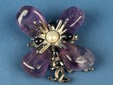 an image of a purple flower brooch with a pearl center