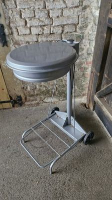 une petite table recouverte d'un couvercle, posée devant un mur de briques
