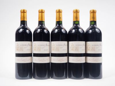 quatre bouteilles de vin sont alignées sur une surface blanche