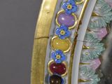a close up of a mirror with a gold frame and colorful beads