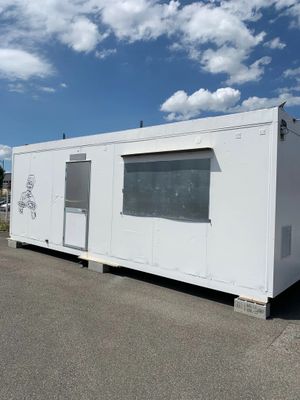 an image of a white container house in a parking lot