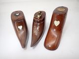 trois paires de sabots en bois ornés de cœurs, posés sur un fond blanc
