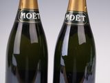 two bottles of moet champagne sitting next to each other