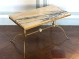 une photo d'une table basse au plateau en marbre posée sur un parquet