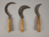 trois types différents de marteaux à manche en bois posés sur une surface blanche