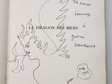 someone is drawing a dragon on a page of a book