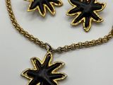 a close up of a necklace and earrings on a white surface