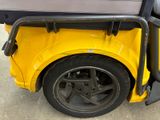 a yellow golf cart with a black seat on it