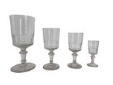 quatre verres à vin posés les uns à côté des autres sur une surface blanche