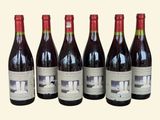 six bouteilles de vin sont alignées sur une table