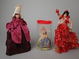 two dolls in a glass jar and a doll in a red dress