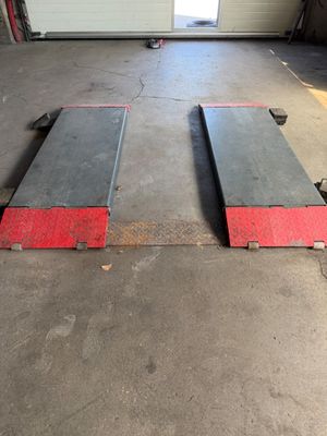 deux rampes noires et rouges dans un garage dont la porte est ouverte