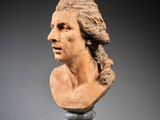 an image of a bust of a man with long hair on a pedestal