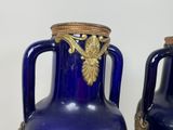 two blue vases that are sitting on a table