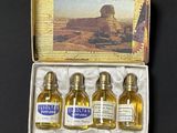 three small bottles of oil in a box with a picture in the background