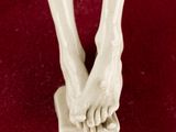 a figurine of a woman ' s legs and feet on a red surface