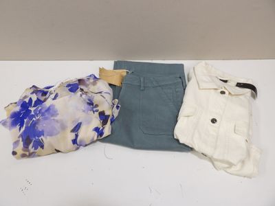 trois vêtements posés sur une table blanche