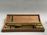 an old brass telescope in a wooden box with a green handle