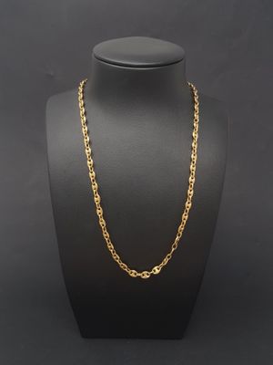 a gold chain necklace on a mannequin display
