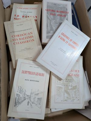 Plusieurs livres se trouvent dans une boîte en carton posée sur une table