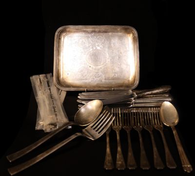 un plateau en argent avec des cuillères, des fourchettes et un plateau sur lequel est posé un miroir