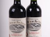 deux bouteilles de vin posées l'une à côté de l'autre sur une surface blanche